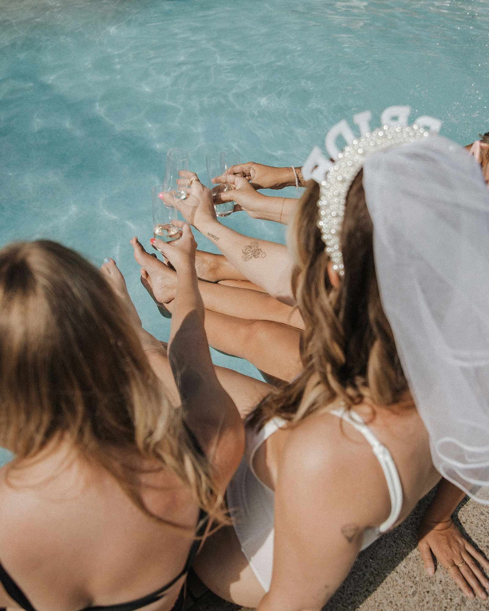 Friends celebrating by the pool — bride squad pool party